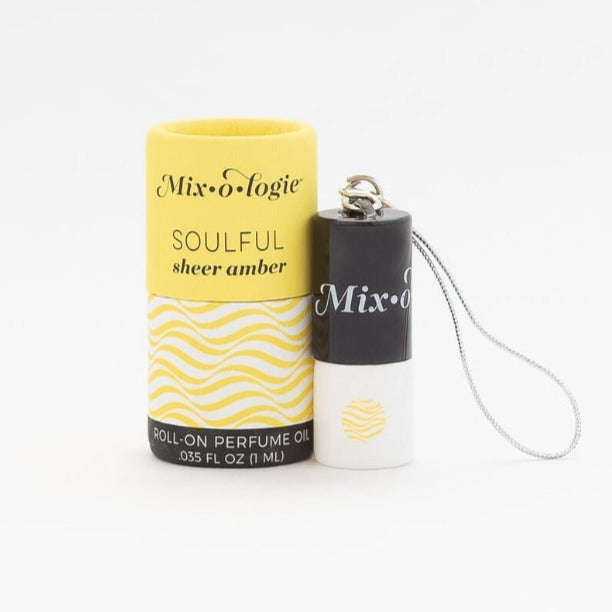 Mixologie's Soulful (sheer amber) scented mini rollerball in 1 mL bottle with keychain lid. displayed with cylinder packaging