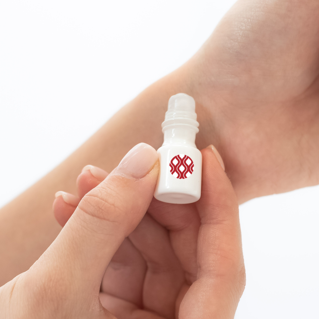 Mixologie's Sultry (wild musk) scented mini rollerball in 1 mL bottle being applied to model's wrist