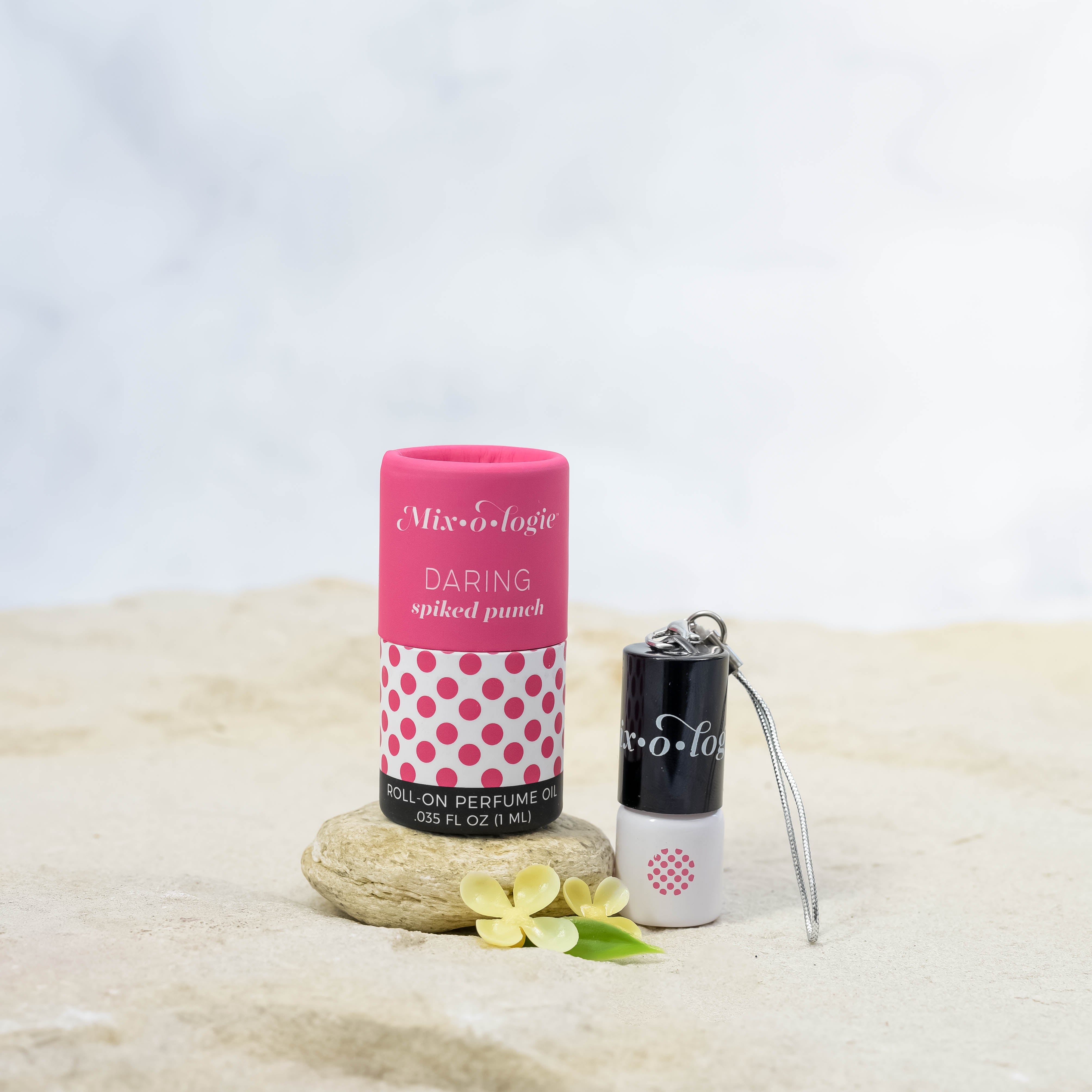 Daring (Spiked Punch) mini white cylinder rollerballs with black top and keychain attachment lid with bright pink polka dots has .035 fl oz or 1 mL.