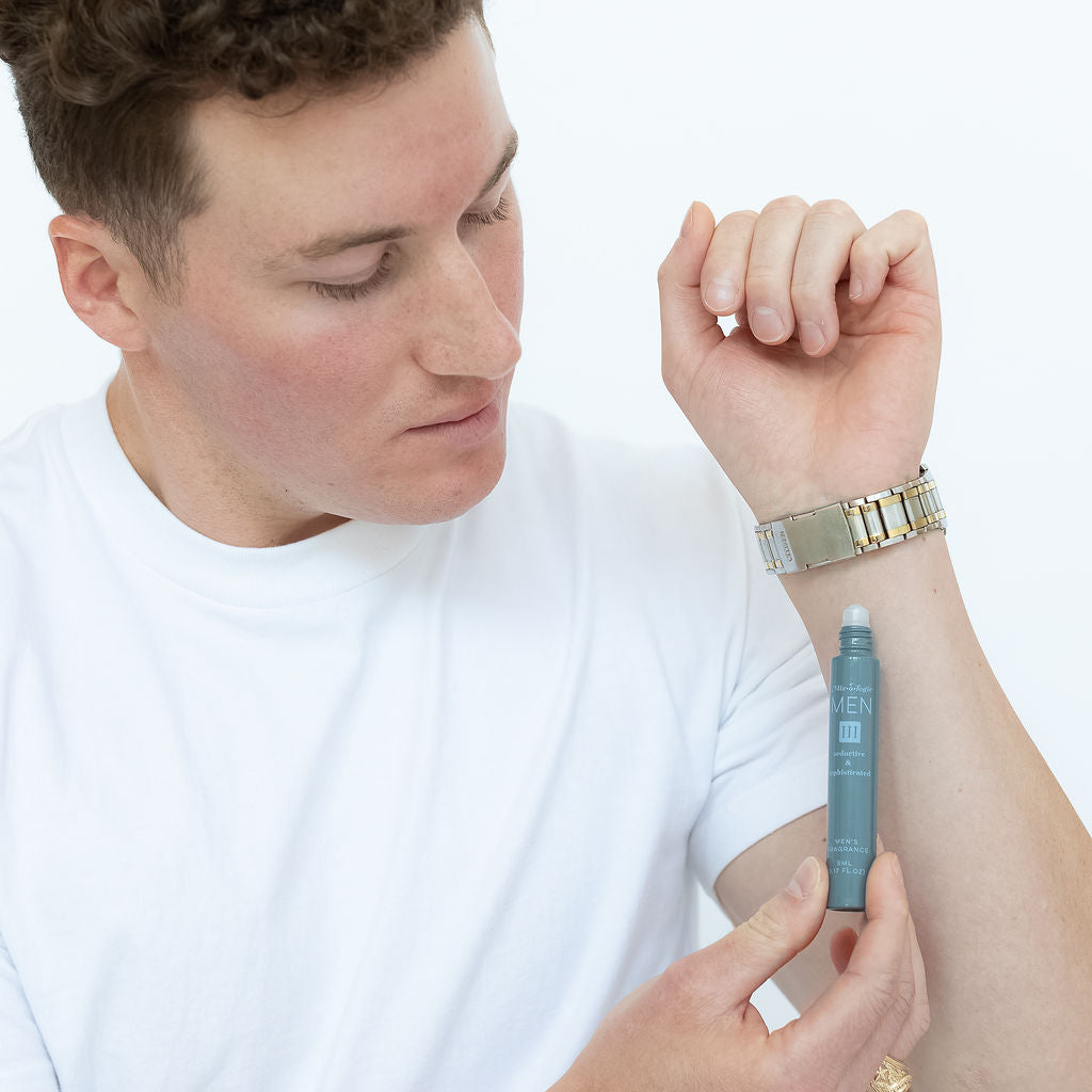 Mixologie rollerball scented with Men's III (seductive & sophisticated) fragrance in 5 mL glass bottle being applied to model's wrist