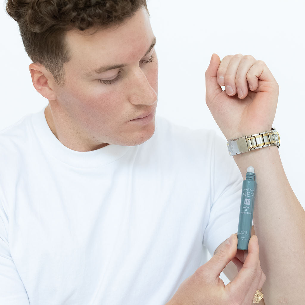 Mixologie rollerball scented with Men's IV (Ardent & Addictive) fragrance in 5 mL glass bottle being applied to model's wrist. 